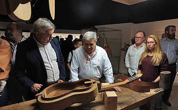 Visitantes contemplan una guitarra en la zona dedicada a los talleres granadinos.