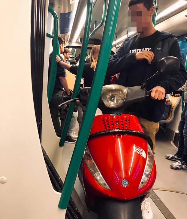 El joven, con su moto dentro del vagón del metro de Granada.