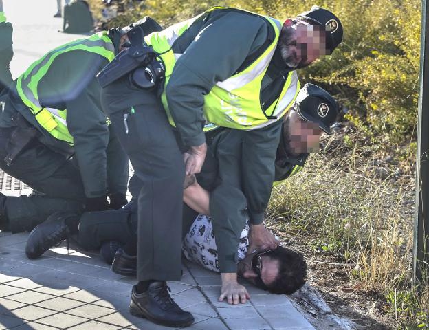 Tres guardias reducen al detenido junto a la rotonda del Serrallo con Huétor Vega. 