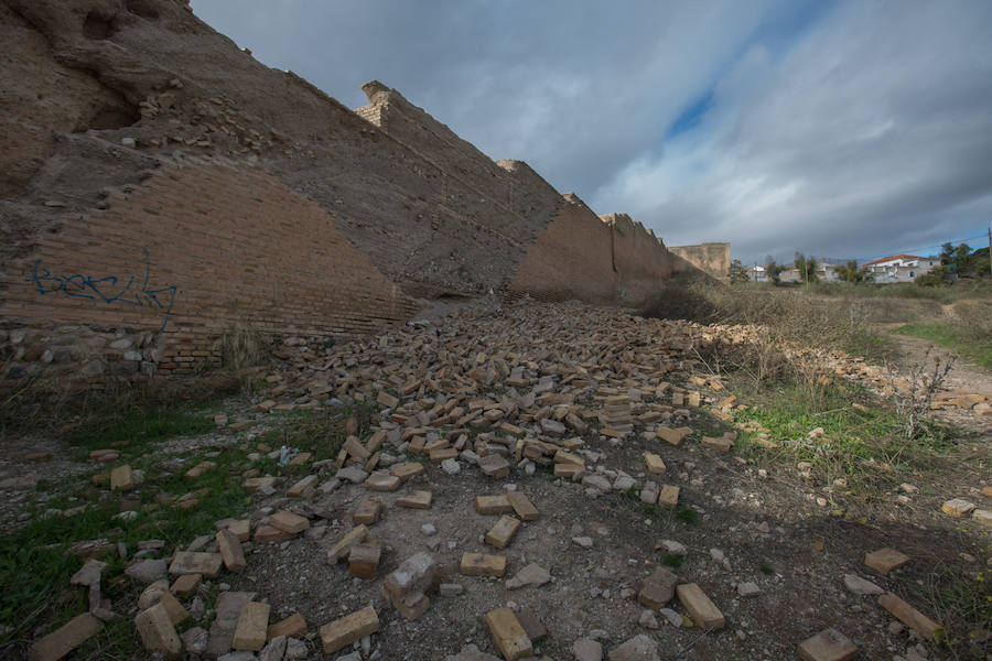 Cientos de ladrillos de lo que prodría ser el revestimiento de la muralla están amontonados junto a restos de basura