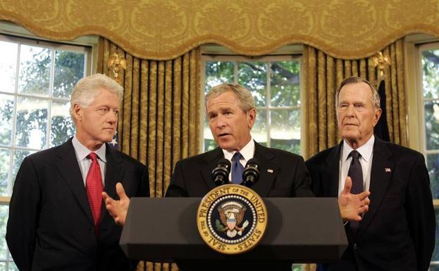 George H. W. Bush junto a su hijo (centro) y al expresidente Bill Clinton (derecha).