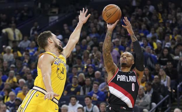 Damian Lillard lanza con la oposición de Klay Thompson. 