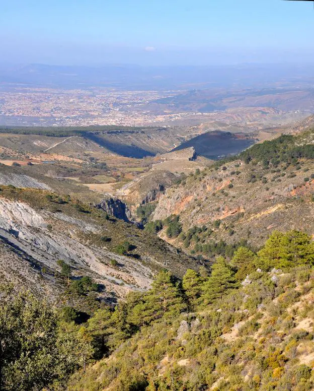 Desde las veredas que ascienden a la cuerda del Trevenque el barranco del río Huenes dirige la vista hacia el valle de Granada.