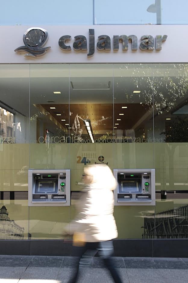 Una señora pasa frente a una oficina de la entidad. 