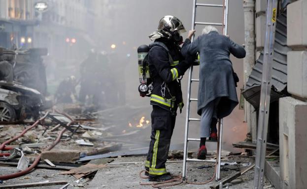 Galería. Un bombero socorre a una anciana.