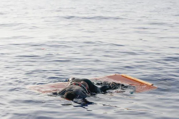 El cuerpo de una mujer yace sobre unas tablas flotando en el mar frente a las costas de Libia. A la izquierda, la forense Cristina Cattaneo.