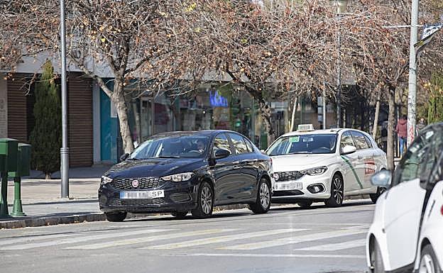 Un coche VTC seguido por un taxi en Granada.