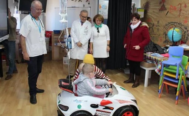 Dos pequeños pasean en el coche de juguete donado por la asociación Argar a Torrecárdenas. 