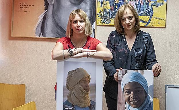 Jara Romero y Gracia Fernández sostienen dos retratos de saharauis en la sede de la asociación.