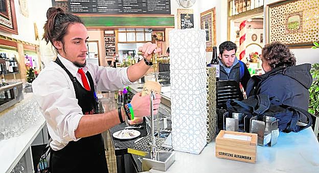 Un camarero tira unas cañas en un establecimiento situado en pleno casco histórico de la capital granadina.
