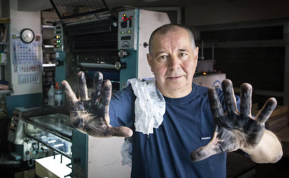 Enrique Alcaide muestra sus manos manchadas de tinta, una imagen alegórica de sus cincuenta años en el oficio de impresor.
