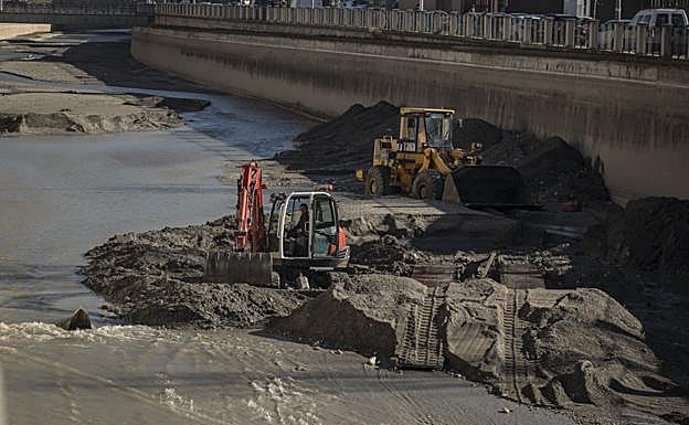 Las máquinas trabajan para sacar la basura del río Genil.