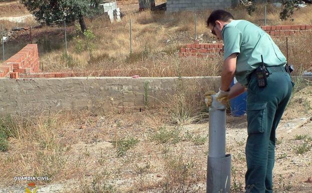 Un agente de la Guardia Civil inspecciona un pozo en Sevilla. 