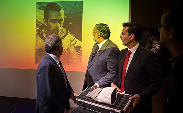 Autoridades muestran el guante de Eugene Cernan, con su foto proyectada, que se podrá ver en el Parque de las Ciencias de Granada.