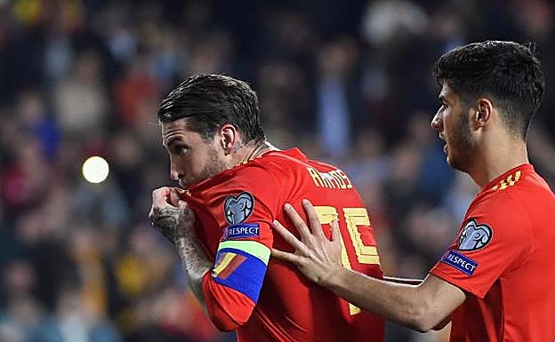 Sergio Ramos, besándose el escudo de la selección española tras anotar el gol de la victoria.