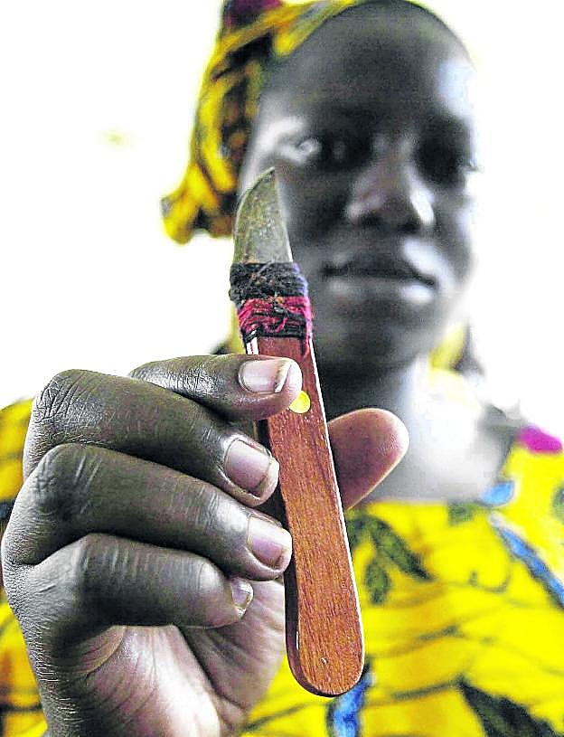 Una mujer de Costa de Marfil muestra la cuchilla que utiliza para realizar ablaciones.