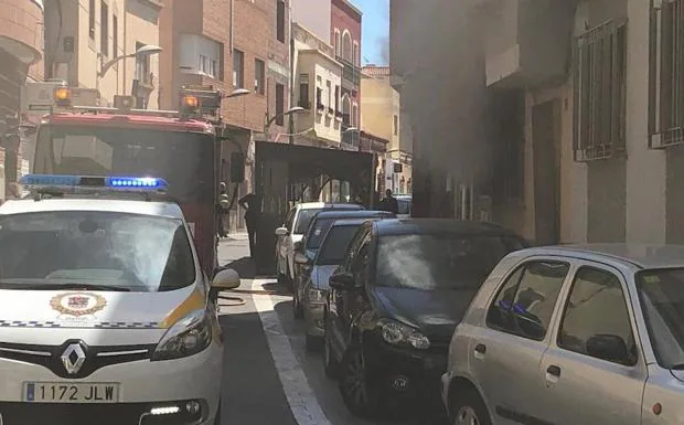 Uno de los vehículos de Bomberos de Almería en la entrada del edificio afectado por el fuego. 