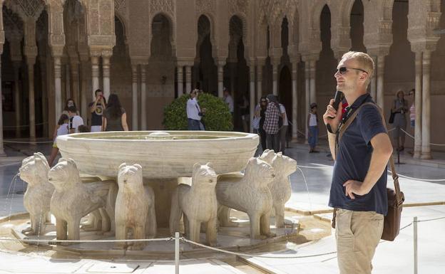 Un turista atiende las explicaciones de una audioguía. 