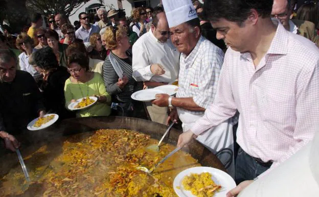 Carlos Rojas reparte platos de arroz en un mitin fiesta de 2008.