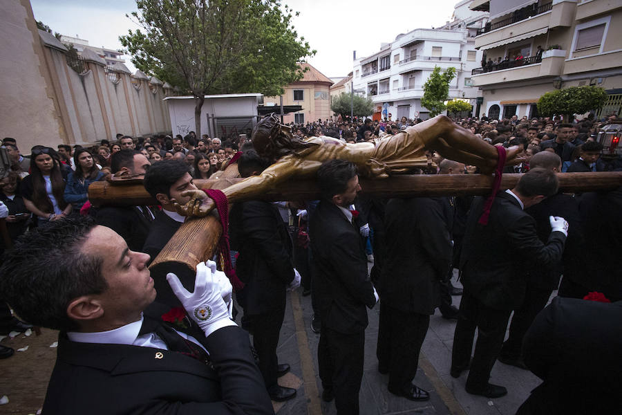 La imagen de Los Agustinos ha salido a la calle sobre las manos de los costaleros y rodeado de decenas de personas que le siguen con una vela encendida