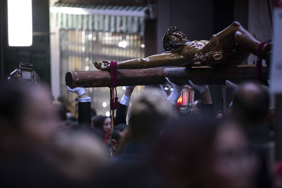 La imagen de Los Agustinos ha salido a la calle sobre las manos de los costaleros y rodeado de decenas de personas que le siguen con una vela encendida