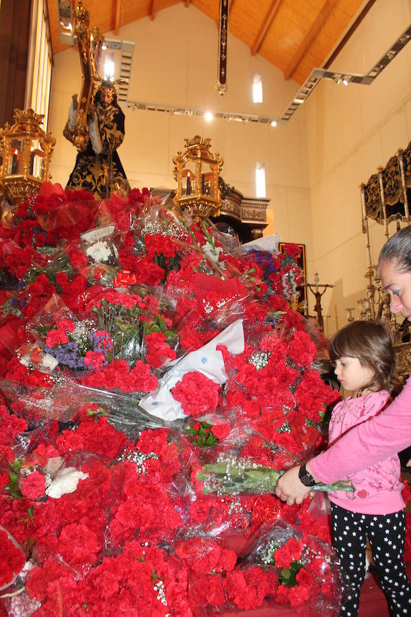 Largas colas pese al mal tiempo y lluvia de claveles para El Abuelo, con un ojo en el cielo a horas de su salida en procesión