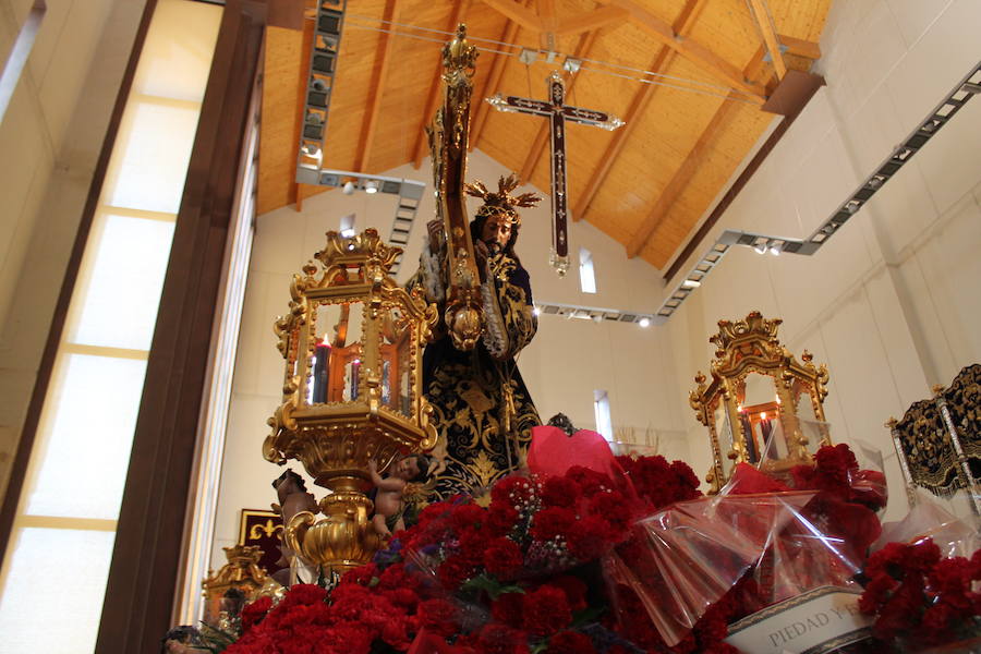 Largas colas pese al mal tiempo y lluvia de claveles para El Abuelo, con un ojo en el cielo a horas de su salida en procesión