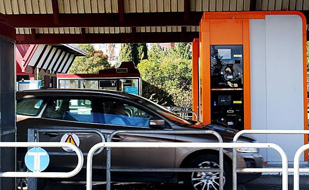 Un coche se apresta a pasar por un puesto de peaje. 