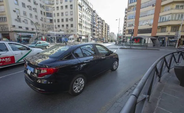 Un vehículo de Uber circula junto a un taxi por Camino de Ronda.