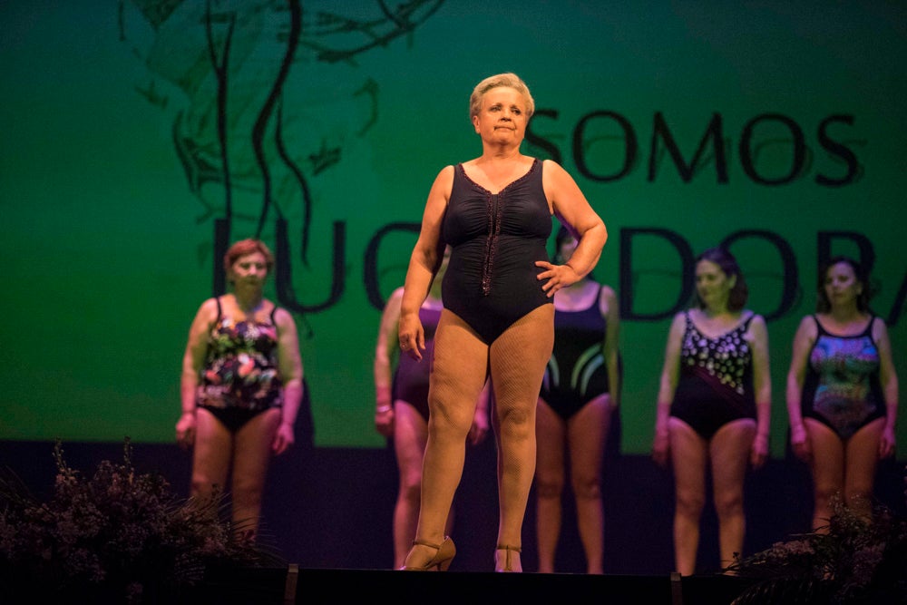 Con el silencio de la sala, en la pantalla se pudieron ver las imágenes de las modelos mostrando sus pechos o, mejor dicho, la falta de ellos en muchos casos. Son mujeres que han padecido cáncer de mama y que querían mostrarse así, al natural. Modelos veteranas, como Nani Aguilar, Antonia Rueda, Cristina Alonso, Conchi Ruiz, Elena Velayos, Lourdes Cabrera, Merce Garzón que se incorporaba este año; junto a la presidenta de AMAMA, Encarna Guerrero. Hubo un recuerdo para Mari Carmen Jiménez, que falleció recientemente.