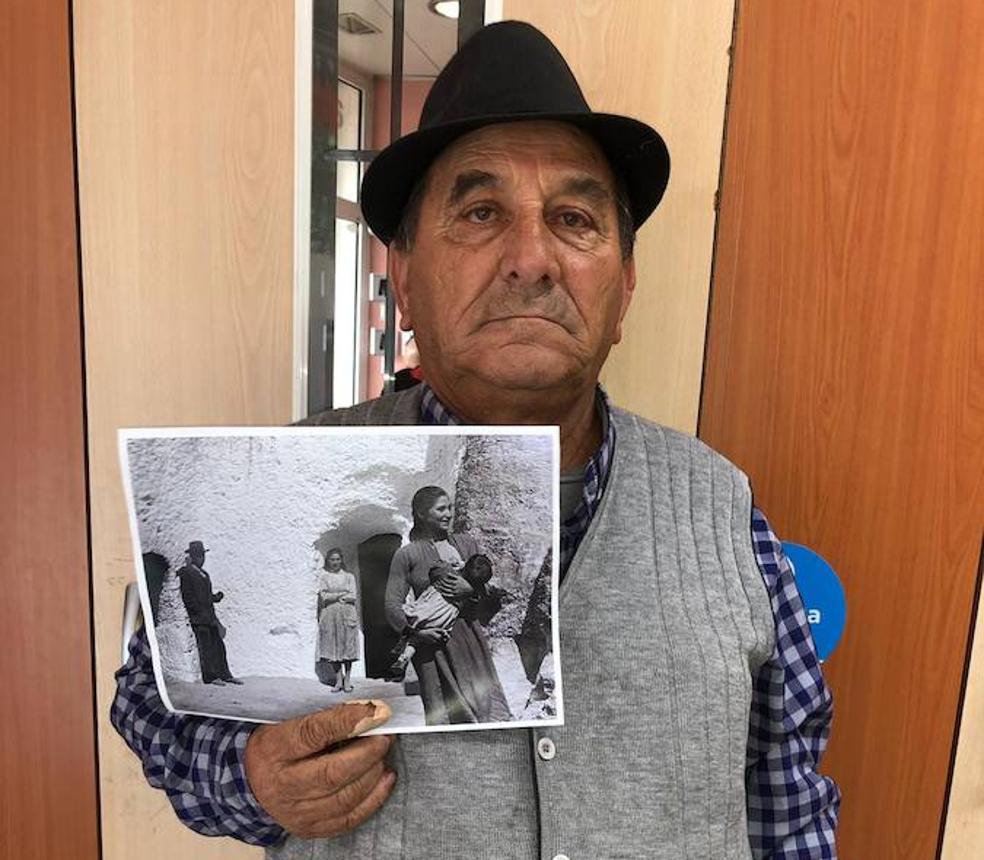 Francisco Heredia, que tiene 64 años y vive en Girona, muestra la foto tomada por Saura donde sale mientras su madre le amamantaba.