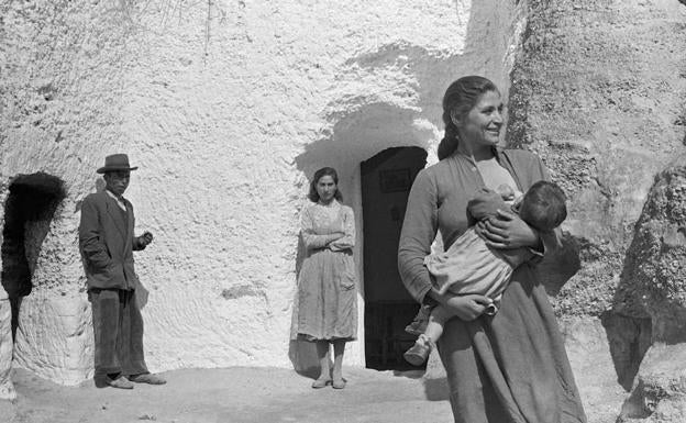 Fotografía de Carlos Saura tomada en las cuevas de Purullena donde se ve, en primer plano a Loreto, sonriente, amamantando a su bebé Francisco.