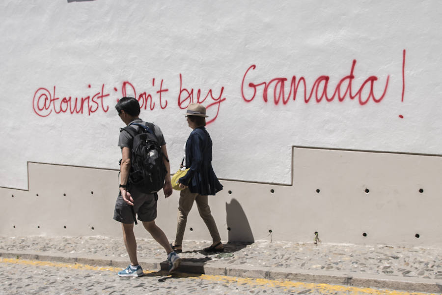 Los grafitis animan a los visitantes a marcharse de la ciudad y les acusan de desvirtuar la esencia del barrio granadino