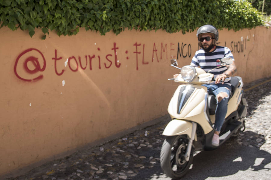 Los grafitis animan a los visitantes a marcharse de la ciudad y les acusan de desvirtuar la esencia del barrio granadino