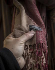 Imagen secundaria 2 - Un agente explica que hay que cumplir las normas a uno de lso comercios de la calle Elvira. Etiqueta de un empresario chino y otra de moda india, en los souvenirs que se venden en el Albaicín.