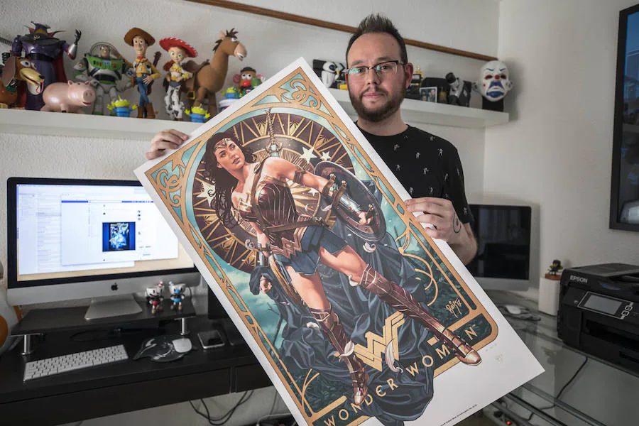 Juan Carlos Ruiz Burgos, en su estudio de Granada, con su póster de 'Wonder Woman', el que más éxito ha tenido hasta la fecha. 
