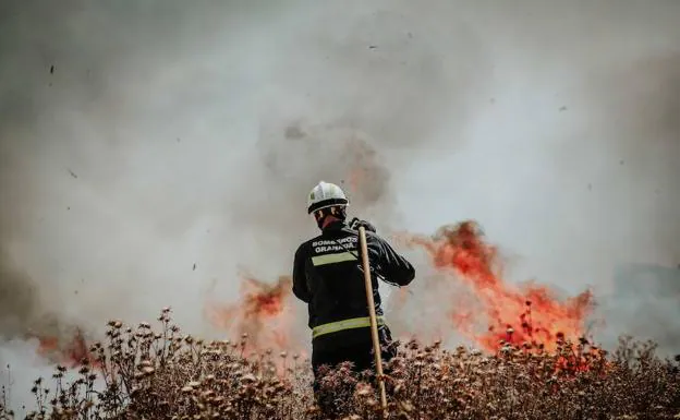 Un bombero trabaja para apagar el fuego en el polígono tecnológico de Ogíjares