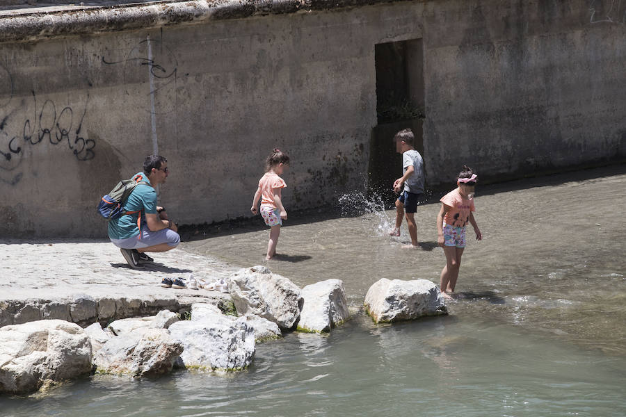 Granadinos y visitantes se las apañan en las calles para no sufrir mucho el enorme calor de estos días