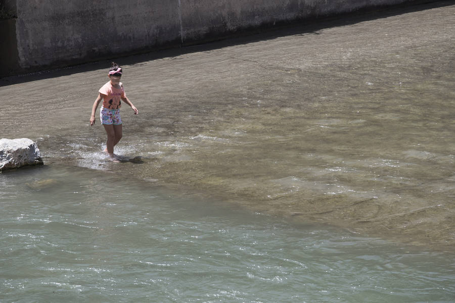 Granadinos y visitantes se las apañan en las calles para no sufrir mucho el enorme calor de estos días