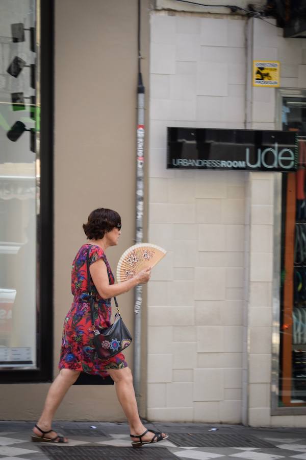 Granadinos y visitantes se las apañan en las calles para no sufrir mucho el enorme calor de estos días