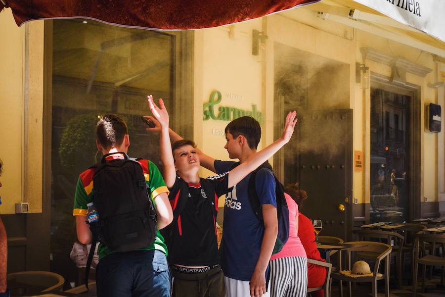 Granadinos y visitantes se las apañan en las calles para no sufrir mucho el enorme calor de estos días
