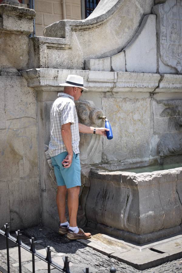 Granadinos y visitantes se las apañan en las calles para no sufrir mucho el enorme calor de estos días