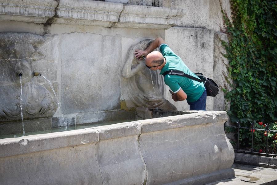 Granadinos y visitantes se las apañan en las calles para no sufrir mucho el enorme calor de estos días