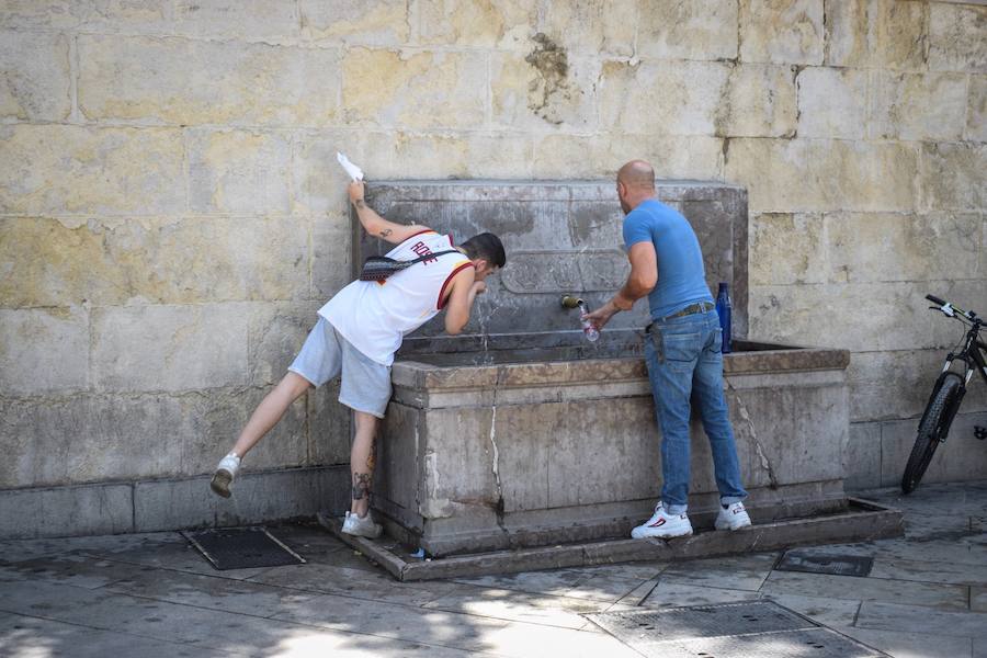 Granadinos y visitantes se las apañan en las calles para no sufrir mucho el enorme calor de estos días