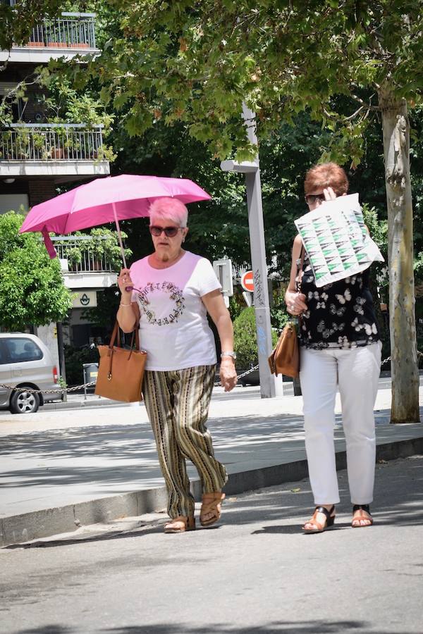 Granadinos y visitantes se las apañan en las calles para no sufrir mucho el enorme calor de estos días