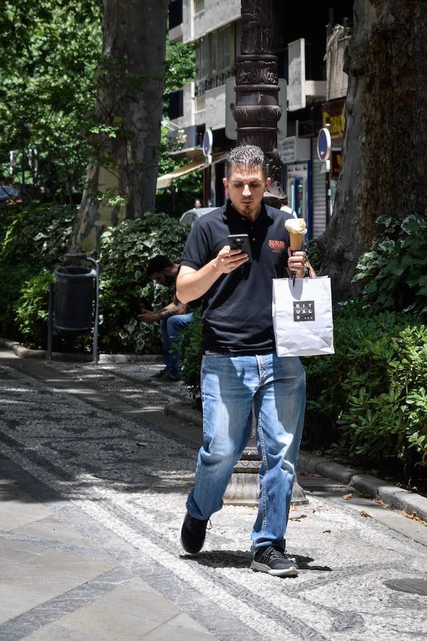 Granadinos y visitantes se las apañan en las calles para no sufrir mucho el enorme calor de estos días
