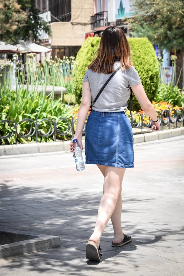 Granadinos y visitantes se las apañan en las calles para no sufrir mucho el enorme calor de estos días