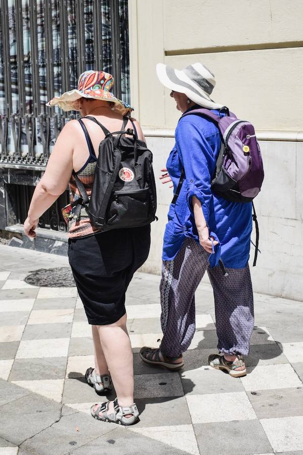 Granadinos y visitantes se las apañan en las calles para no sufrir mucho el enorme calor de estos días