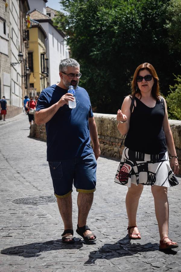 Granadinos y visitantes se las apañan en las calles para no sufrir mucho el enorme calor de estos días