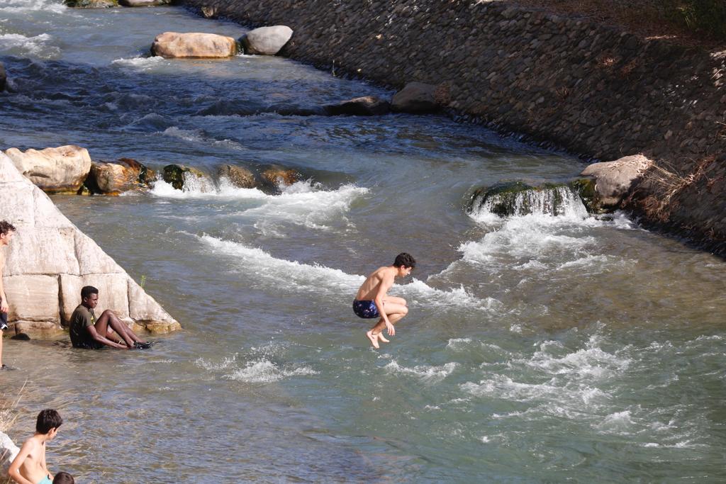 Granadinos y visitantes se las apañan en las calles para no sufrir mucho el enorme calor de estos días
